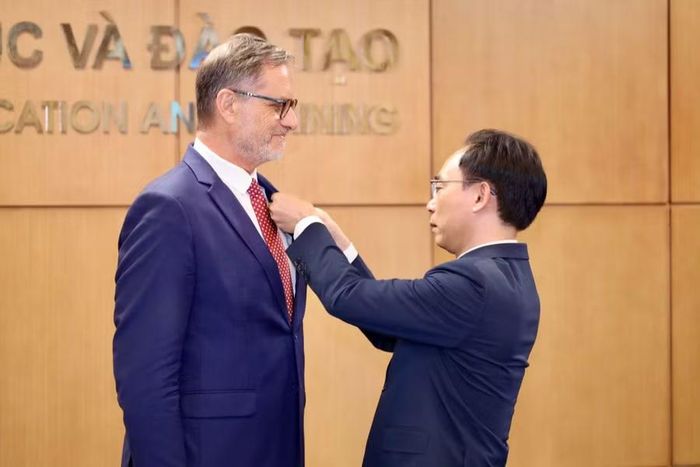 Bộ trưởng Hoàng Minh Sơn gắn Kỷ niệm chương cho Đại sứ Olivier Brochet.