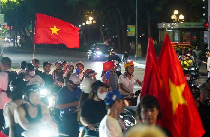 Trên phố Đinh Tiên Hoàng, từng đoàn xe mang theo cờ đỏ sao vàng nối nhau di chuyển. Tiếng còi xe, tiếng kèn và tiếng reo hò vang khắp khu vực hồ Hoàn Kiếm.