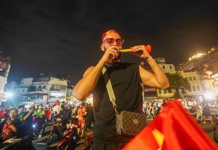 Càng về khuya, không khí tại khu vực hồ Hoàn Kiếm càng náo nhiệt. Nhiều cổ động viên khoác áo đội tuyển, quấn cờ Tổ quốc, thổi kèn và ghi lại khoảnh khắc ăn mừng.