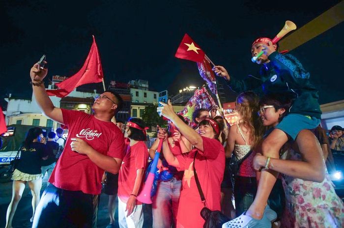 Ngay sau khi trận bán kết lượt về ASEAN Cup 2026 giữa Việt Nam và Malaysia kết thúc, hàng nghìn người hâm mộ đổ về Quảng trường Đông Kinh Nghĩa Thục. Cờ đỏ sao vàng tung bay quanh khu vực đài phun nước, tiếng reo hò và những bài hát cổ vũ đội tuyển vang lên giữa đêm.