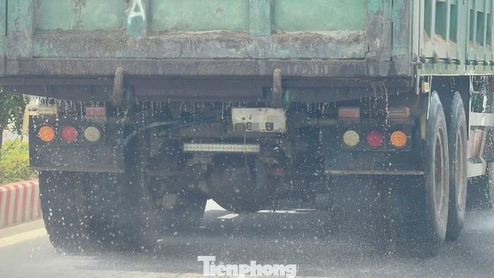 Nước và cát chảy lênh láng trên mặt đường.