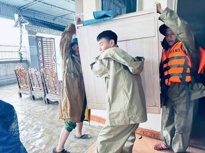Công an xã Can Lộc cùng lực lượng an ninh, trật tự ở cơ sở hỗ trợ người dân kê cao, di chuyển tài sản đến nơi an toàn khi nước lũ tràn vào nhà.