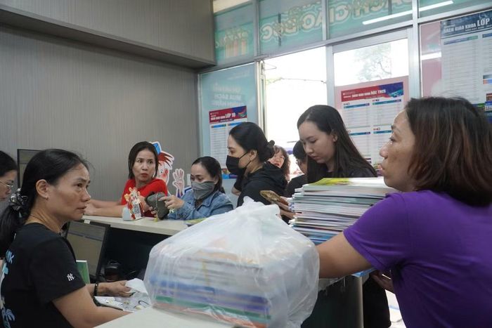 Phụ huynh chờ mua SGK cho con tại cửa hàng sách của Nhà xuất bản Giáo Dục