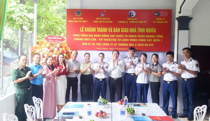 Các đại biểu chụp ảnh lưu niệm với gia đình Thiếu tá Trần Quang Tĩnh.