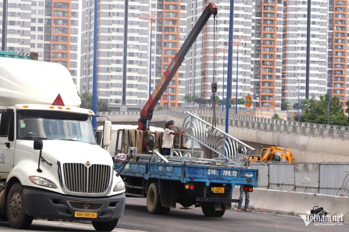 Xe cẩu chuyên dụng lắp lan can bảo vệ dọc thành nhánh N4. Ảnh: Tuấn Kiệt