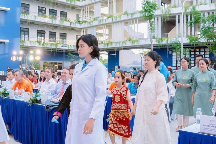 Thúy Anh (áo trắng, đi đầu) trong buổi lễ khánh thành trường mới ngày 8/8/2025