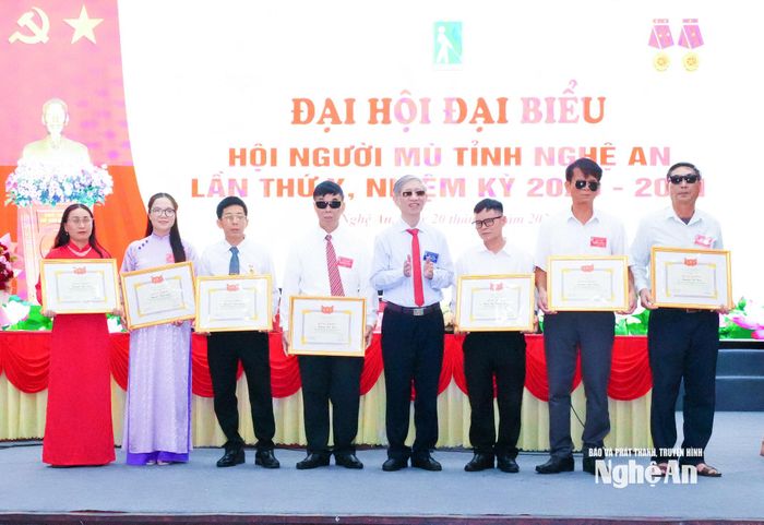 Chủ tịch Hội Người mù Việt Nam Phạm Viết Thu tặng Bằng khen cho 7 cá nhân. Ảnh: Mai Hoa