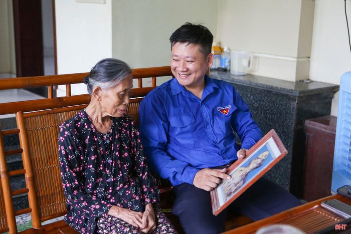 Anh Đặng Văn Cường cùng bà ngoại xem lại bức hình kỷ niệm của ông ngoại là cụ Nguyễn Văn Bật (1932-2021) chụp thời kỳ tham gia kháng chiến chống Pháp.