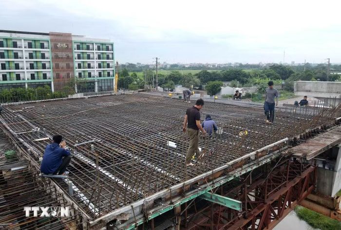 Công nhân lắp đặt cốt thép bản mặt cầu thuộc cầu vượt đường Vành đai 4 qua Quốc lộ 1A. (Ảnh: Vũ Quang/TTXVN)