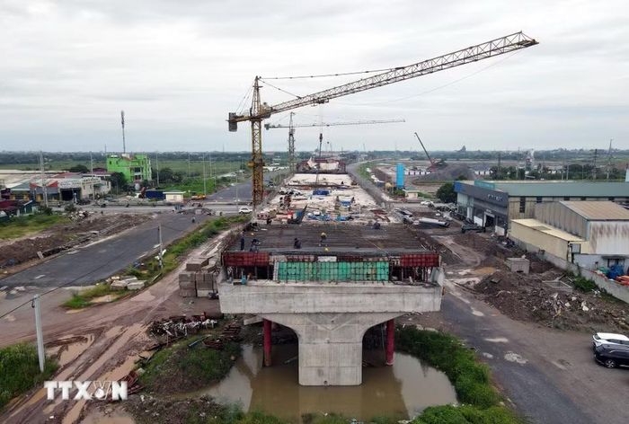 Cần cẩu và thiết bị được huy động thi công kết cấu nhịp cầu vượt Vành đai 4 qua Quốc lộ 1A. (Ảnh: Vũ Quang/TTXVN)