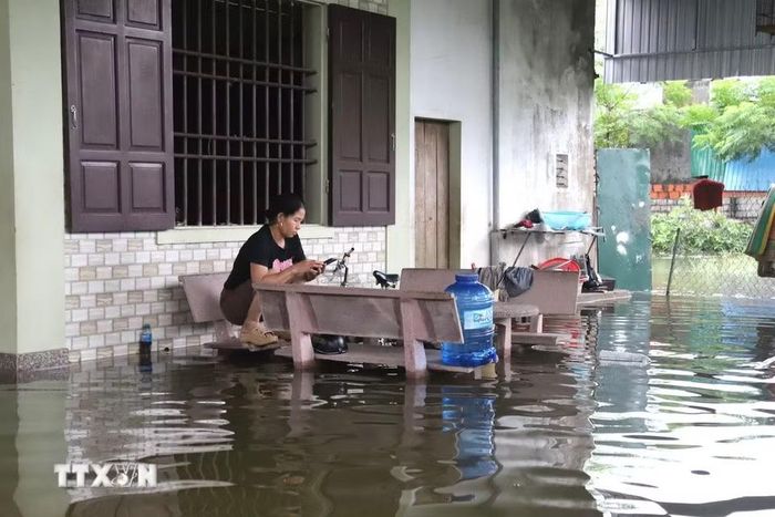 Nước ngập sâu vào hiên nhà, sinh hoạt của người dân gặp nhiều khó khăn. (Ảnh: Xuân Tiến/TTXVN)