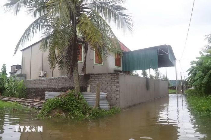 Tuyến ngõ vào khu dân cư tại Đồng tháng 5 (xóm Hải Bắc và Quyết Thành cũ, xã Diễn Châu) ngập sâu, nước bao vây tường nhà dân. (Ảnh: Xuân Tiến/TTXVN)