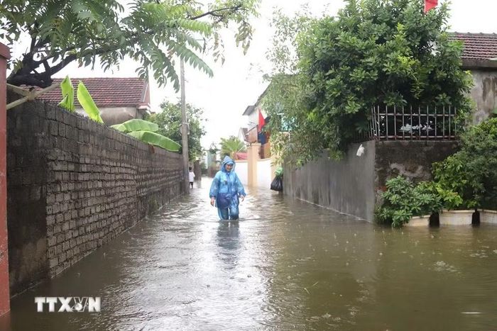 Tuyến đường liên xóm tại Đồng tháng 5 (xóm Hải Bắc và Quyết Thành cũ, xã Diễn Châu) ngập sâu, biến đường thành sông. (Ảnh: Xuân Tiến/TTXVN)