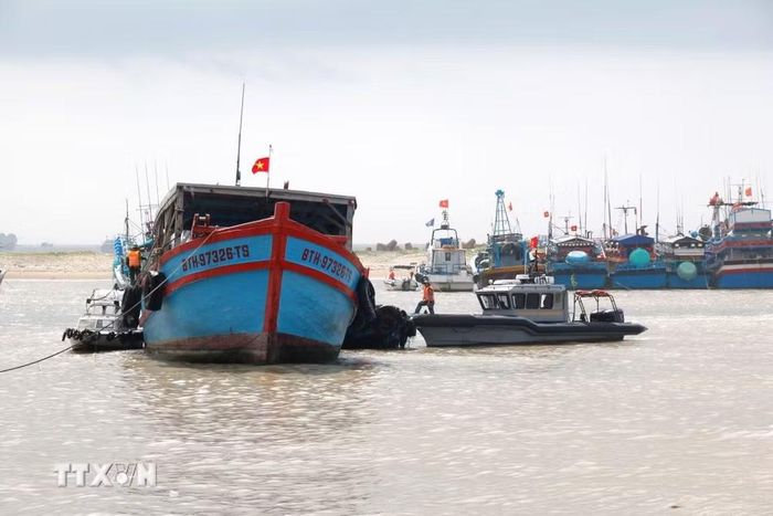 Lực lượng bộ đội biên phòng kiểm tra tàu cá ra vào tại cảng cá La Gi. (Ảnh: Nguyễn Thanh/TTXVN)