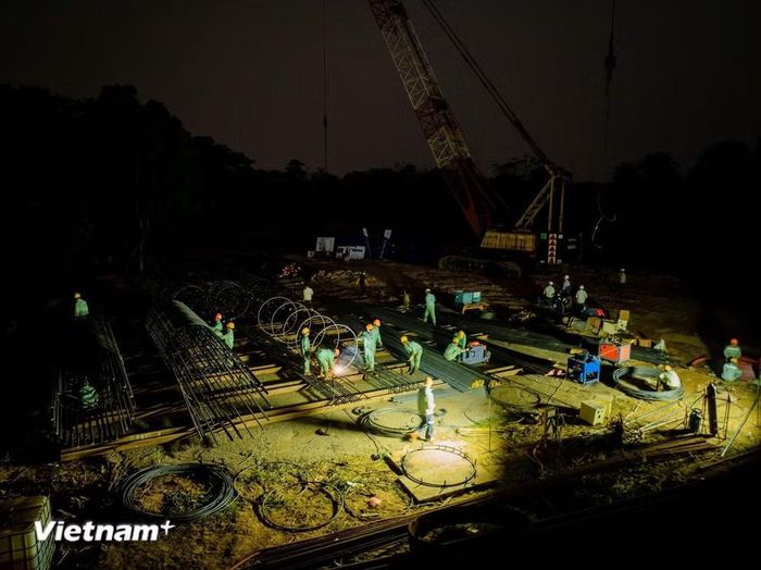 Nhà thầu và công nhân thi công liên tục ngày, đêm để đẩy nhanh tiến độ các cầu vượt sông Hồng, thành phố Hà Nội. (Ảnh: PV/Vietnam+)
