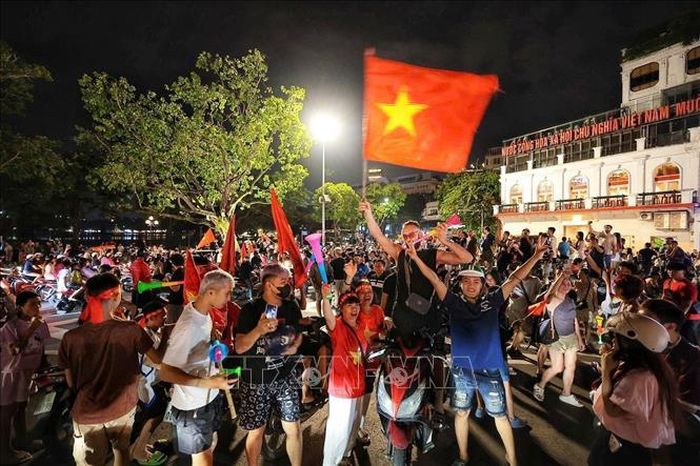 Du khách nước ngoài hòa cùng niềm vui chiến thắng của đội tuyển Việt Nam. Ảnh: Phạm Tuấn Anh/TTXVN