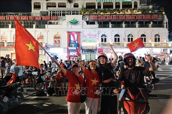 Du khách nước ngoài hòa cùng niềm vui chiến thắng của đội tuyển Việt Nam. Ảnh: Phạm Tuấn Anh/TTXVN
