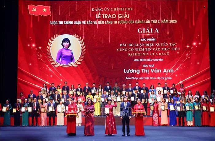 Đồng chí Đoàn Minh Huấn, Ủy viên Bộ Chính trị, Giám đốc Học viện Chính trị quốc gia Hồ Chí Minh, Phó Trưởng Ban Chỉ đạo 35 Trung ương và đồng chí Nguyễn Thị Tuyến, Ủy viên Trung ương Đảng, Phó Bí thư chuyên trách Đảng ủy Chính phủ trao Giải A cho các tác giả đạt giải. Ảnh: Phạm Kiên/TTXVN