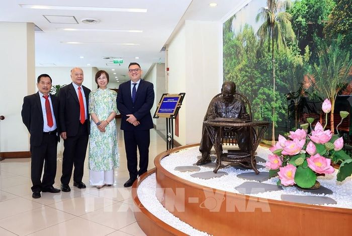 Các đại biểu chụp ảnh chung bên bức tượng “Bác Hồ ngồi làm việc trong vườn hoa Phủ Chủ tịch”, do nhà điêu khắc người Mexico Pedro Ramirez Ponzanelli sáng tác và Đảng Lao động Mexico tặng TTXVN. Ảnh: Tuấn Anh - TTXVN