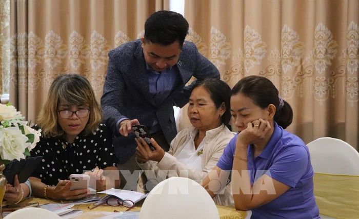 Hướng dẫn học viên thực hành trên điện thoại. Ảnh: Nguyễn Hằng - TTXVN