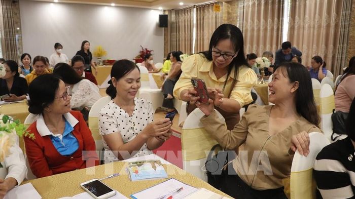 Đại diện Hội Liên hiệp phụ nữ thành phố hỗ trợ học viên thực hành ứng dụng AI trên điện thoại. Ảnh: Nguyễn Hằng - TTXVN