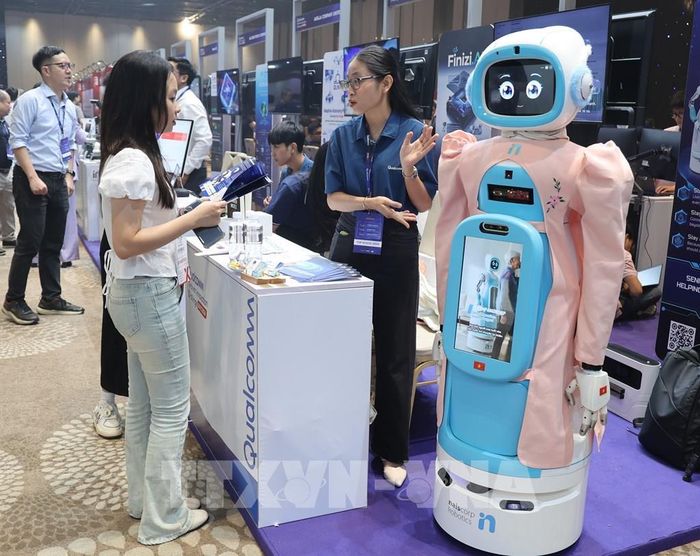 Khách tham quan tìm hiểu mô hình robot chăm sóc người già tại gian hàng của Qualcomm. Ảnh: Hứa Chung-TTXVN 