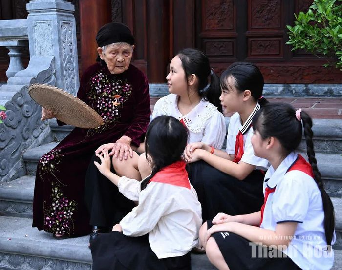 Học sinh chăm chú lắng nghe Mẹ Việt Nam Anh hùng Phan Thị Mùi kể chuyện về những năm tháng chiến tranh. Ảnh: Phạm Hưng