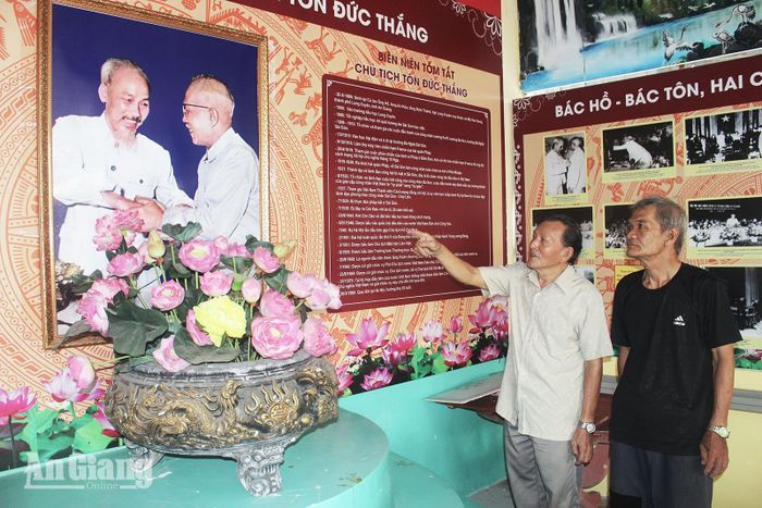 Ông Phạm Văn Chua (bên trái), Phó trưởng Ban Trị sự Phật giáo Hòa Hảo xã Mỹ Hòa Hưng giới thiệu Không gian văn hóa về cuộc đời và sự nghiệp của Chủ tịch Hồ Chí Minh và Chủ tịch Tôn Đức Thắng trong khuôn viên Ban Trị sự Phật giáo Hòa Hảo xã Mỹ Hòa Hưng. Ảnh: PHƯƠNG LAN