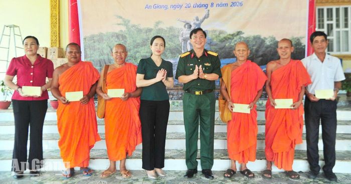 Đại tá Bùi Văn Minh, Chính ủy Sư đoàn 4 và Phó Chủ tịch UBND xã Hòn Đất Đào Thị Thu Huyền tặng quà người có uy tín, chức sắc tiêu biểu trên địa bàn xã.