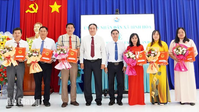 Bí thư Đảng ủy xã Bình Hòa Lê Phước Dũng (thứ tư, từ trái qua) và Chủ tịch UBND xã Bình Hòa Nguyễn Tấn Phong trao quyết định thành lập các trường.