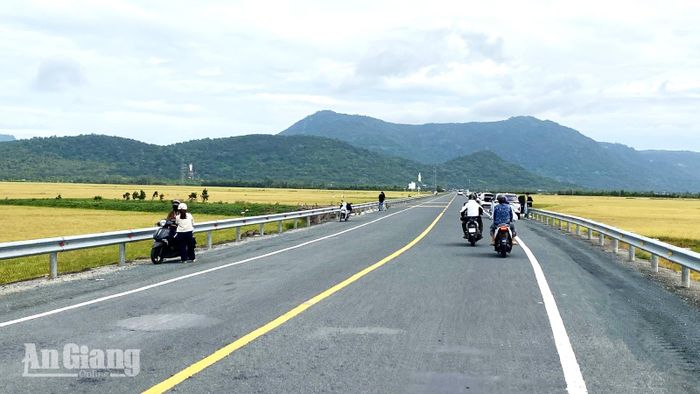 Tình trạng người dân dừng phương tiện dưới lòng đường tuyến tránh Tri Tôn để chụp ảnh tiềm ẩn nguy cơ tai nạn.