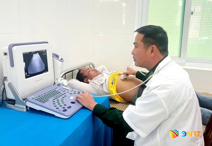 Thiếu tá, bác sĩ Nguyễn Văn Quốc Trí khám bệnh cho người dân. Ảnh: HUỲNH CHÍN