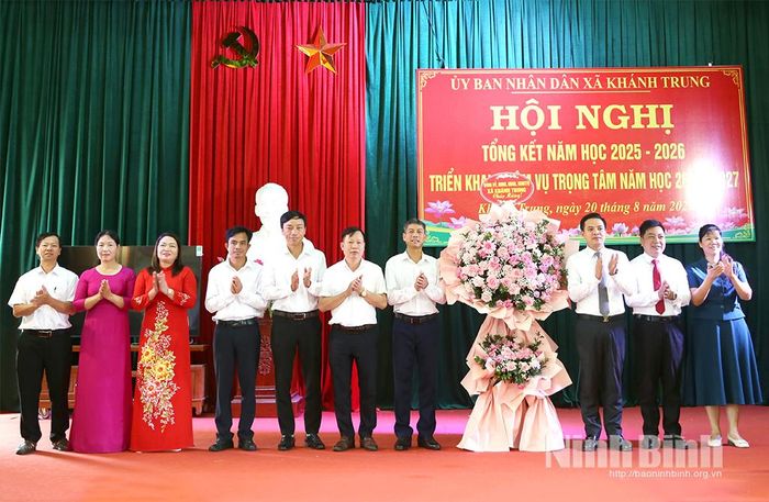 Lãnh đạo xã Khánh Trung tặng hoa chúc mừng thành tích ngành giáo dục địa phương.
