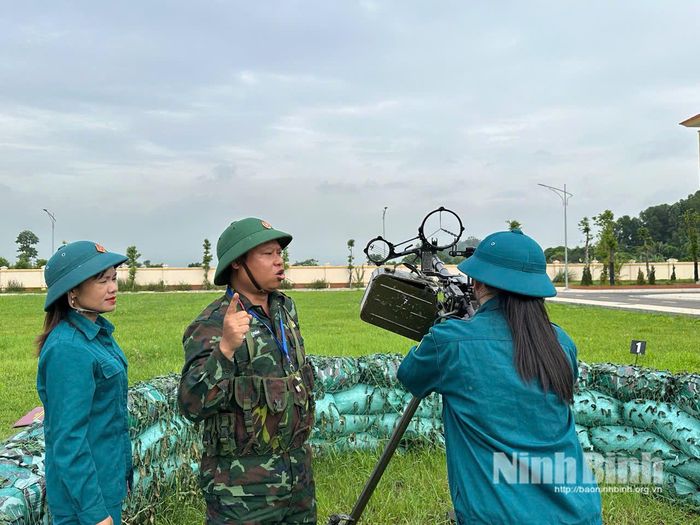 Giáo viên hướng dẫn thao tác bắn súng máy phòng không 12,7mm cho nữ chiến sĩ dân quân.