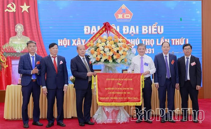 Đồng chí Chủ tịch Tổng Hội Xây dựng Việt Nam Đặng Việt Dũng tặng lẵng hoa và bức trướng chúc mừng Đại hội. 
