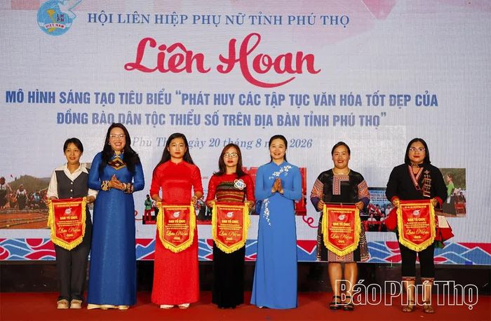 Đồng chí Bùi Thị Minh - Phó Bí thư Tỉnh ủy, Chủ tịch Ủy ban MTTQ tỉnh cùng lãnh đạo Hội LHPN tỉnh tặng cờ lưu niệm cho các đội tham gia liên hoan.