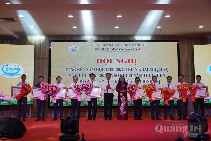 Đồng chí Hoàng Nam, Phó Chủ tịch Thường trực UBND tỉnh Hoàng Nam và lãnh đạo Sở Giáo dục và Đào tạo trao bằng khen của Thủ tướng Chính phủ, tặng hoa chúc mừng các cá nhân - Ảnh: H.L