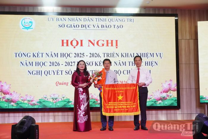 Đồng chí Hoàng Nam, Phó Chủ tịch Thường trực UBND tỉnh và lãnh đạo Sở Giáo dục và Đào tạo trao cờ thi đua của Thủ tướng Chính phủ, tặng hoa chúc mừng tập thể Trường phổ thông Dân tộc nội trú THPT Nam Quảng Trị - Ảnh: H.L