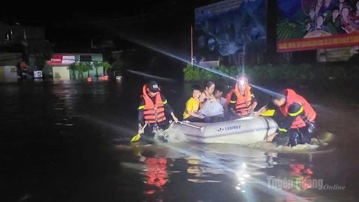 Lực lượng Công an giúp người dân di chuyển đến khu vực an toàn ngay trong đêm, khi nước lũ tràn về.