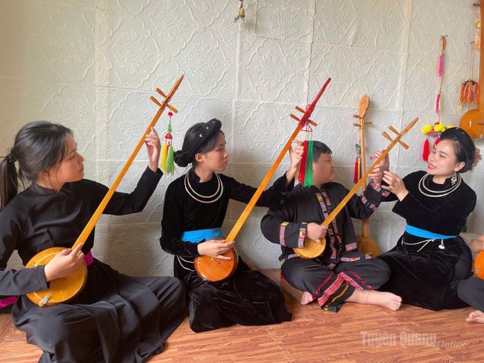 Chị Phương Thúy hướng dẫn các em nhỏ cách đánh đàn Tính.