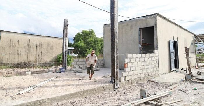  Một hộ dân ở thôn Bình An dọn dẹp vật liệu, chấp hành yêu cầu ngừng xây dựng khi chính quyền địa phương đến tuyên truyền, giải thích.