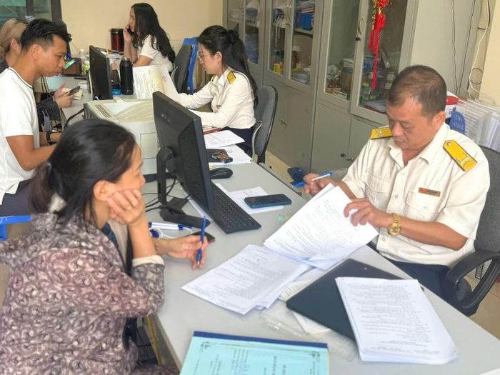 Công chức Thuế cơ sở 2 (Thuế Quảng Ninh) hướng dẫn người nộp thuế thực hiện các dịch vụ thuế điện tử. Ảnh Thuế Quảng Ninh