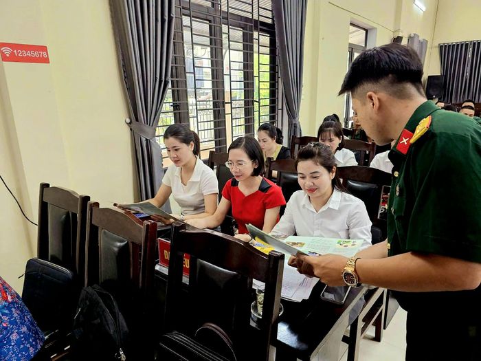 Cán bộ Trung đoàn 148 (Sư đoàn 316) phát tài liệu tuyên truyền pháp luật cho đại biểu tham dự hội nghị tại phường An Tường. Ảnh: Thành Tuyên