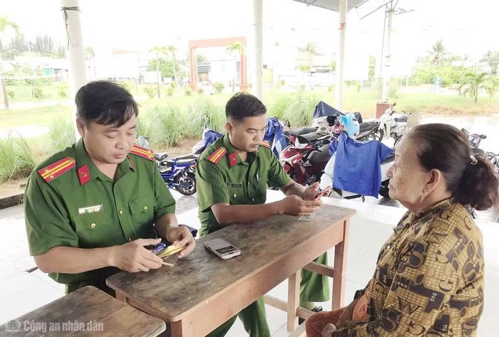 Cán bộ Công an xã Hưng Hội hỗ trợ người dân lớn tuổi sử dụng tài khoản VNeID.