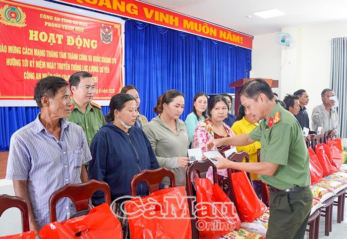 Trung tá Trần Xuân Lãm, Đội trưởng Đội Viễn thông - Cơ yếu, Phòng Tham mưu, Công an tỉnh, trao quà cho người dân ấp Thành Vọng.