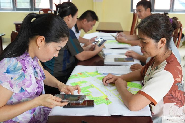 Cán bộ xã Nam Phù đối soát, quét và cập nhật thông tin dữ liệu đất đai của người dân lên phần mềm dữ liệu. Ảnh: Khánh Huy