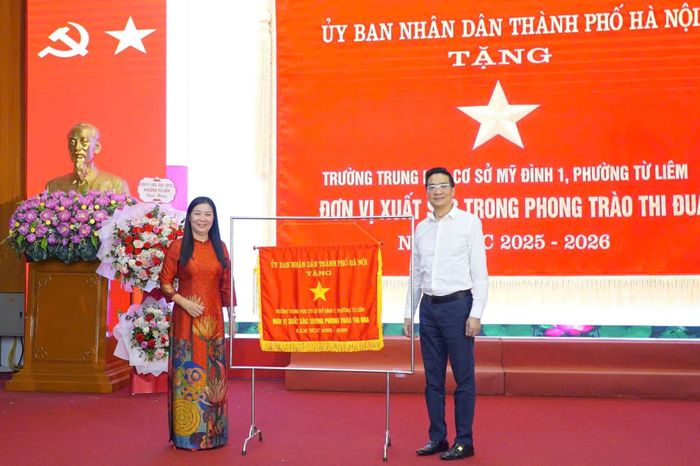 Lãnh đạo phường Từ Liêm trao Cờ thi đua của UBND thành phố Hà Nội cho tập thể Trường THCS Mỹ Đình 1. Ảnh: PV