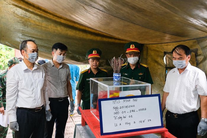 Lãnh đạo Đảng ủy, Ủy ban MTTQ Việt Nam xã Kim Anh bàn giao hài cốt liệt sĩ để lực lượng chuyên môn tiến hành xác định danh tính. Ảnh Sỹ Hào