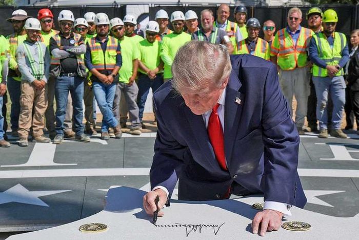 Tổng thống Donald Trump ký lên phiến đá là một phần của bãi đáp trực thăng mới ở Bãi cỏ phía Nam Nhà Trắng. Ảnh: Alex Wong/Getty Images