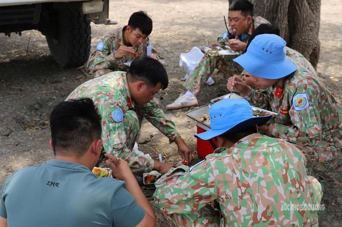 Bữa cơm của những người lính mũ nồi xanh ngay bên tuyến thi công. Ảnh: Văn Mậu
